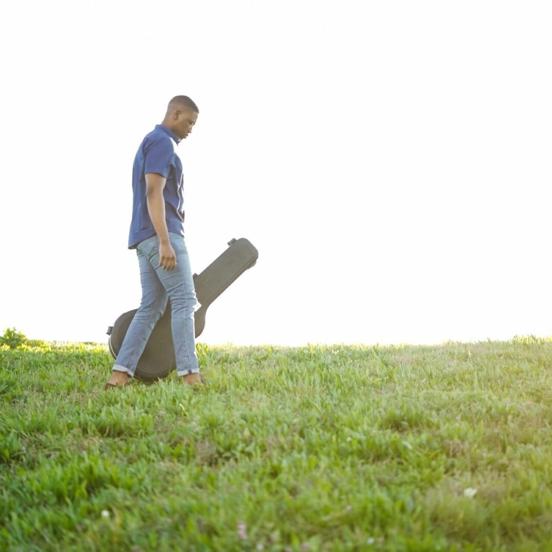 A man holding his guitar in a case